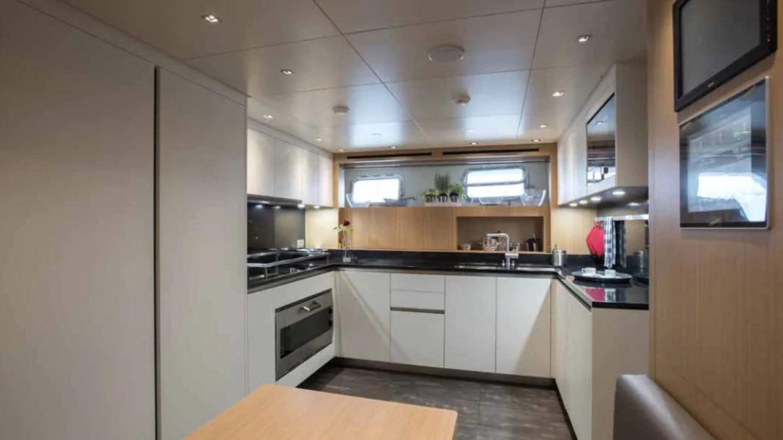 a kitchen with white cabinets aboard MUMA Yacht for Sale