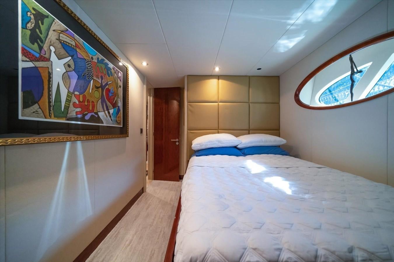 a room with a bed and a painting on the wall aboard GOLDEN LADY Yacht for Sale