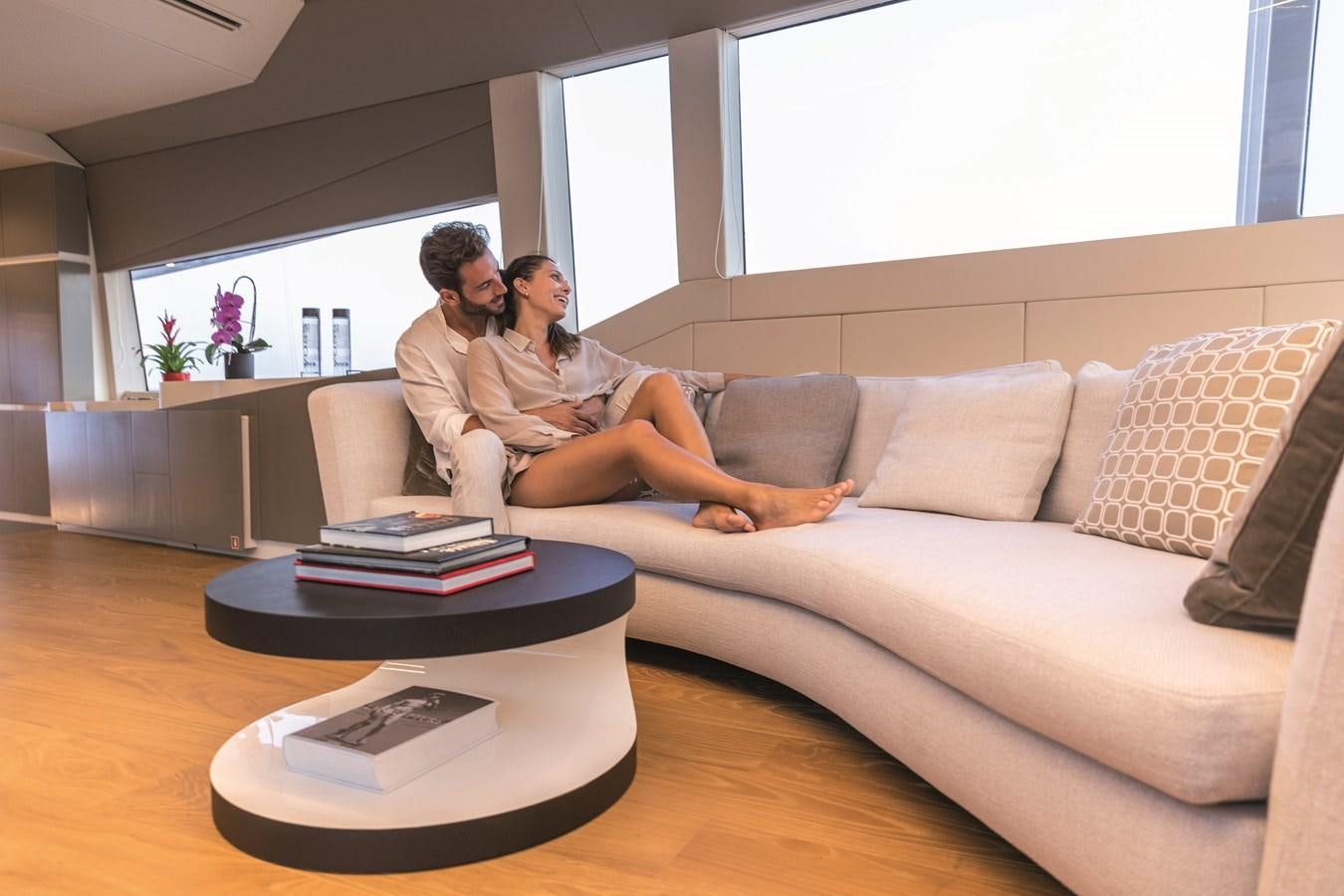 a couple of men sitting on a couch kissing aboard SONEY Yacht for Sale