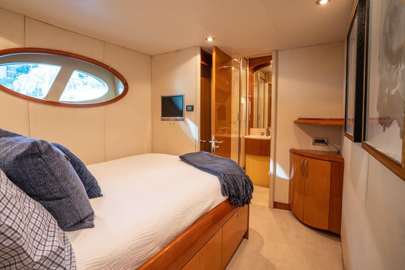 a bedroom with a bed and a tv on the wall aboard EDITA  Yacht for Sale