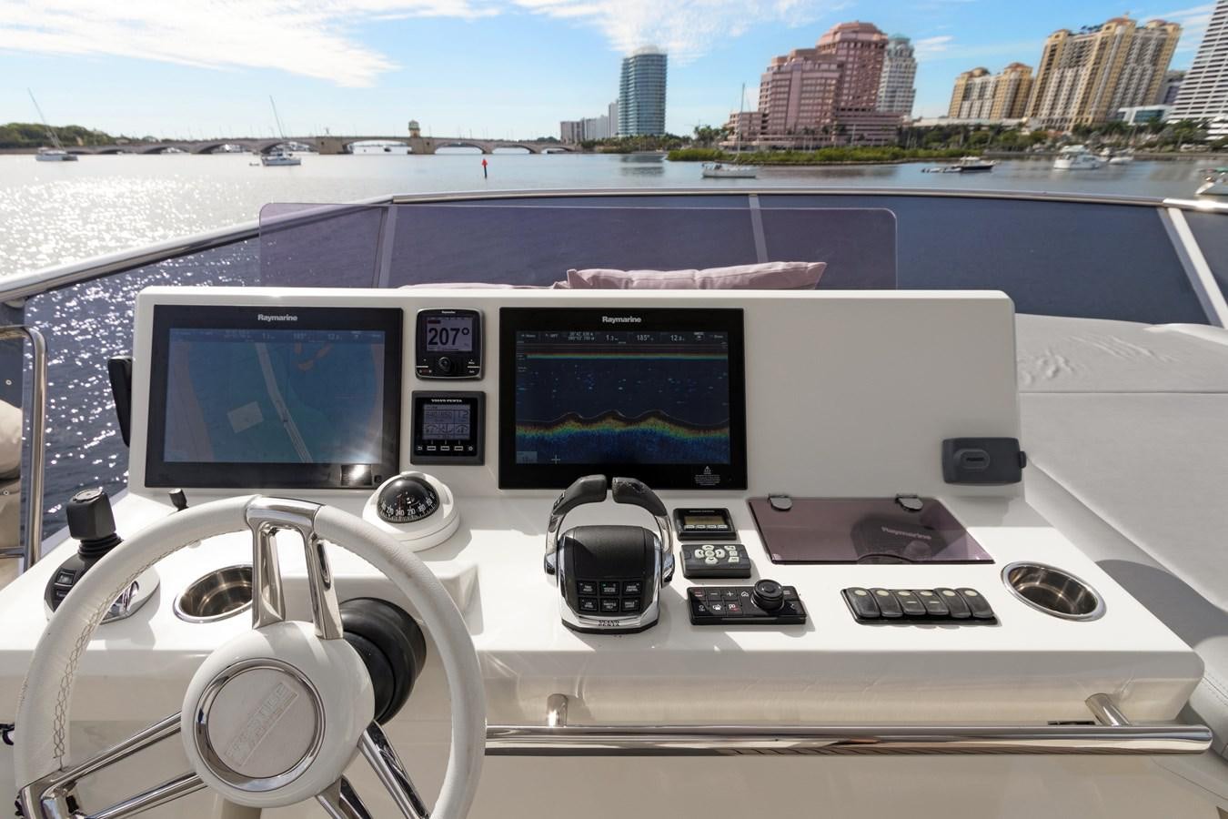 a large white boat with a computer monitor and a large city in the background aboard JUIL OF THE SEA Yacht for Sale