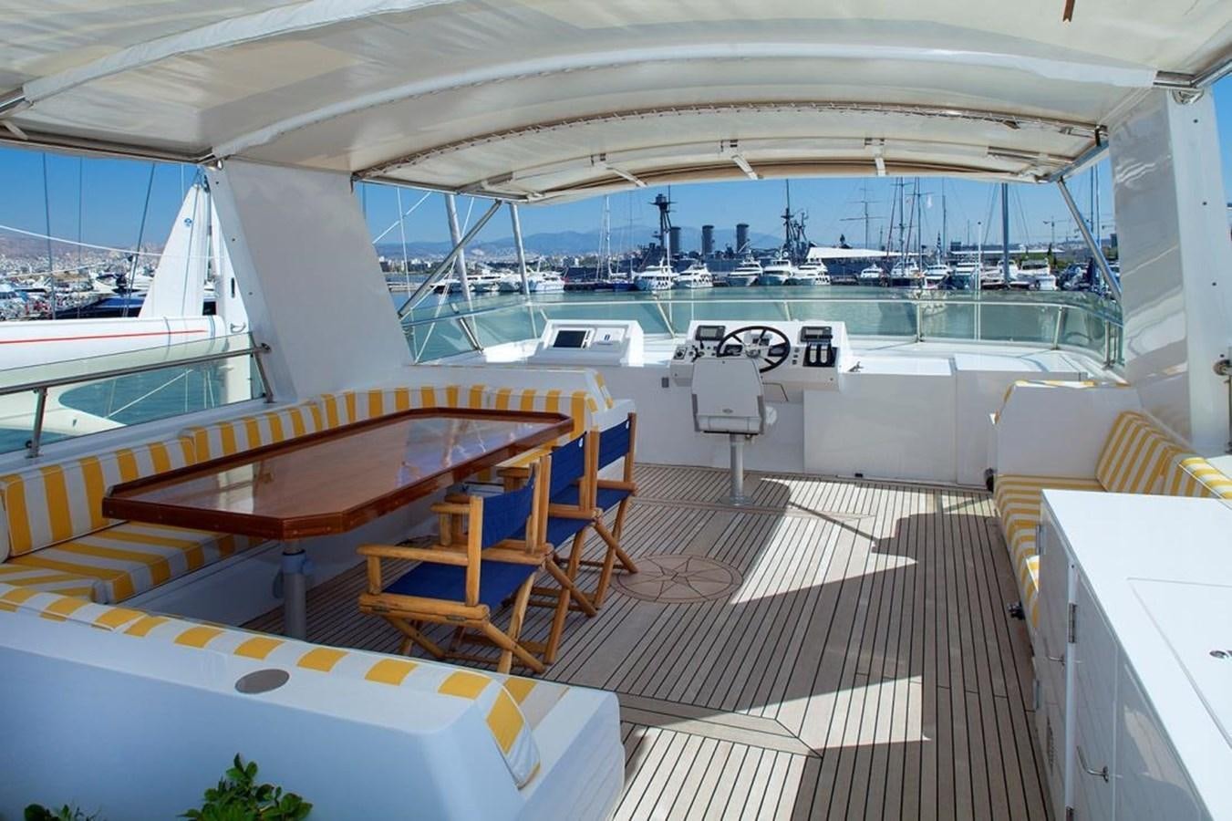 a room with a deck and chairs aboard ARMATHIA Yacht for Sale
