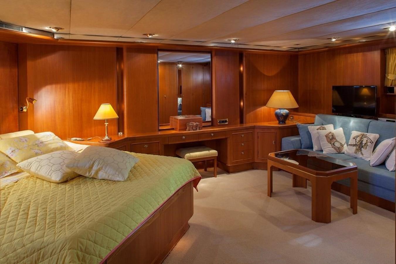 a bedroom with a bed and a table aboard ARMATHIA Yacht for Sale