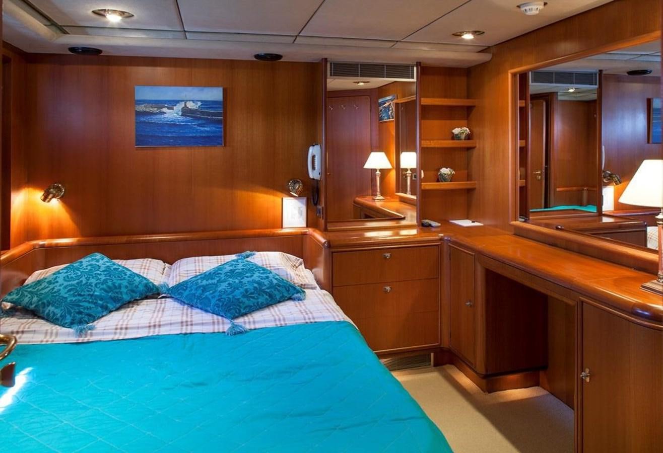 a bedroom with a bed and desk aboard ARMATHIA Yacht for Sale