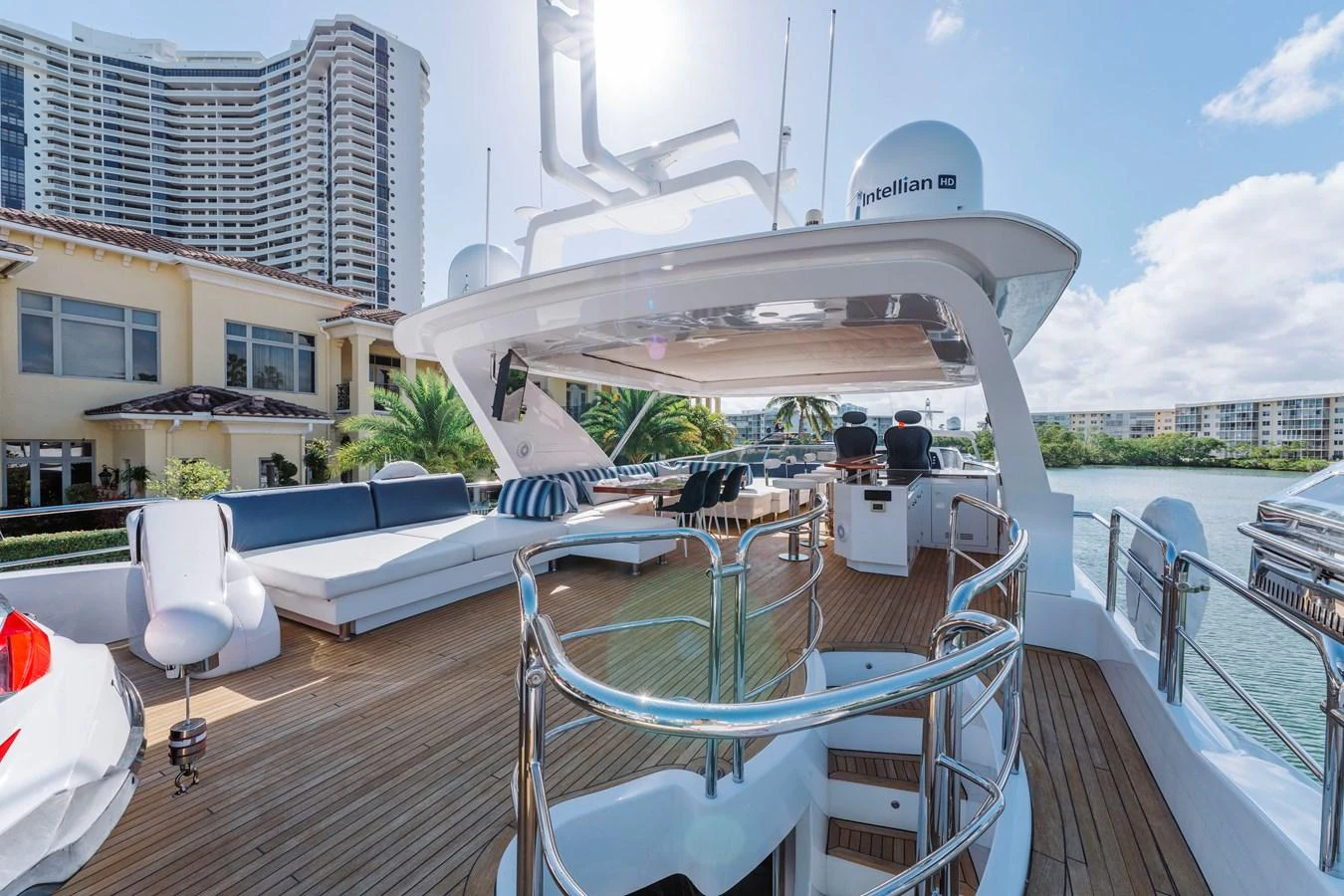 a deck with a large white building and a pool with chairs and tables aboard RESET Yacht for Sale