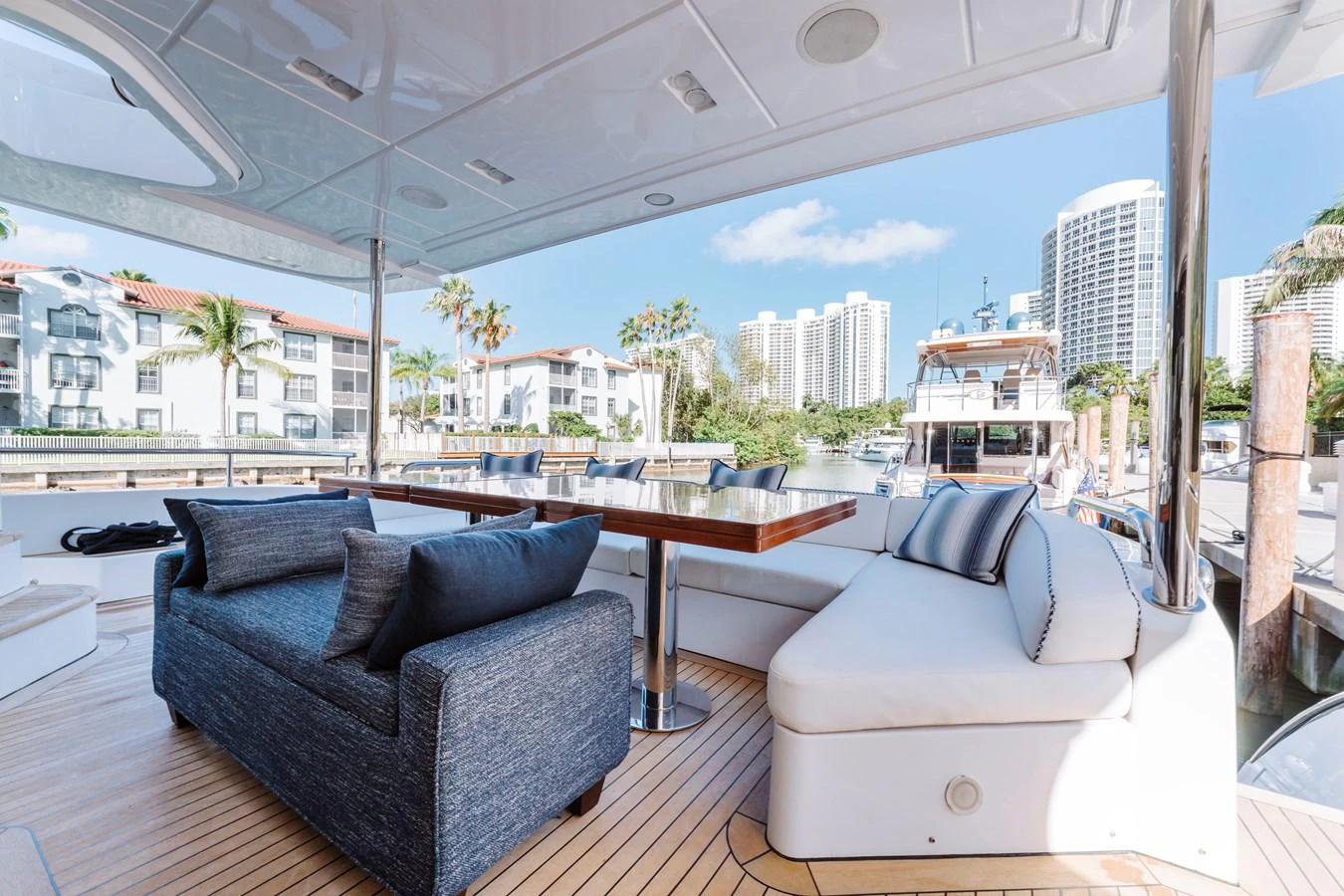 a room with a couch and a table and a view of a city aboard RESET Yacht for Sale