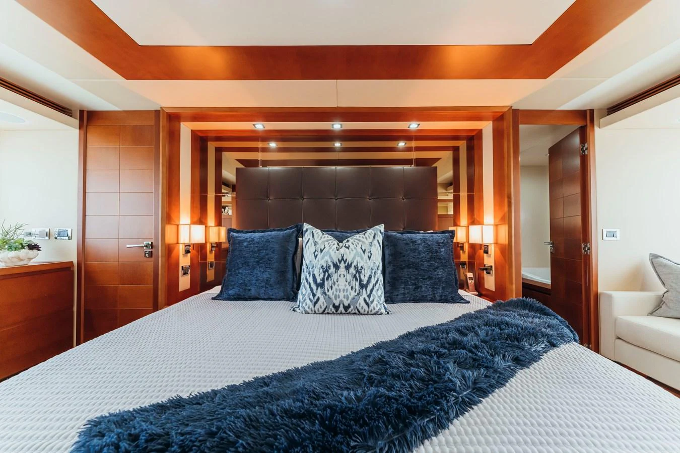 a bed with blue pillows aboard RESET Yacht for Sale
