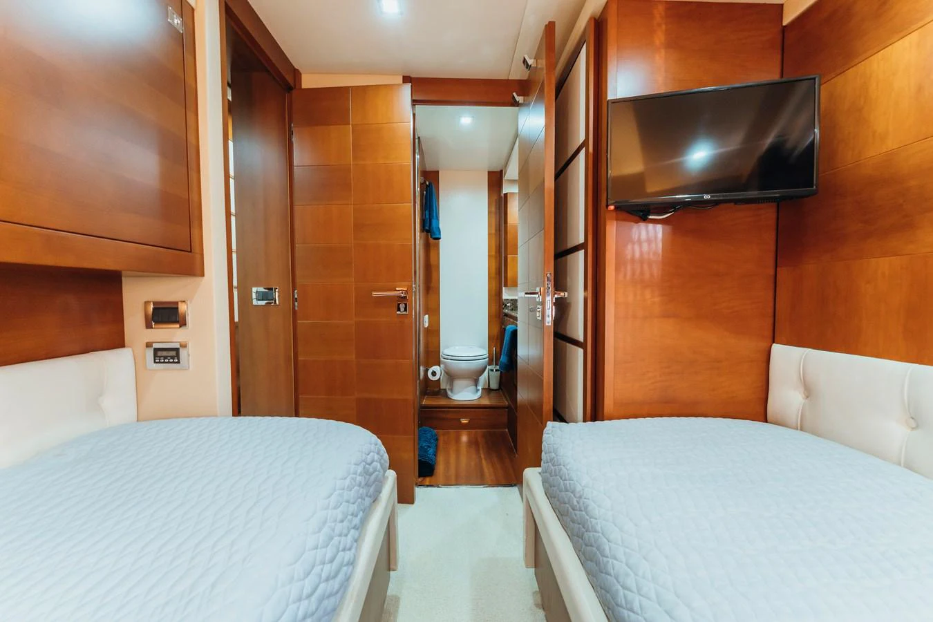 a room with a bed and a television aboard RESET Yacht for Sale