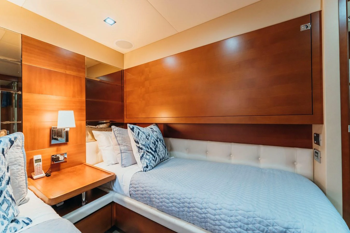 a bed with a blue comforter aboard RESET Yacht for Sale
