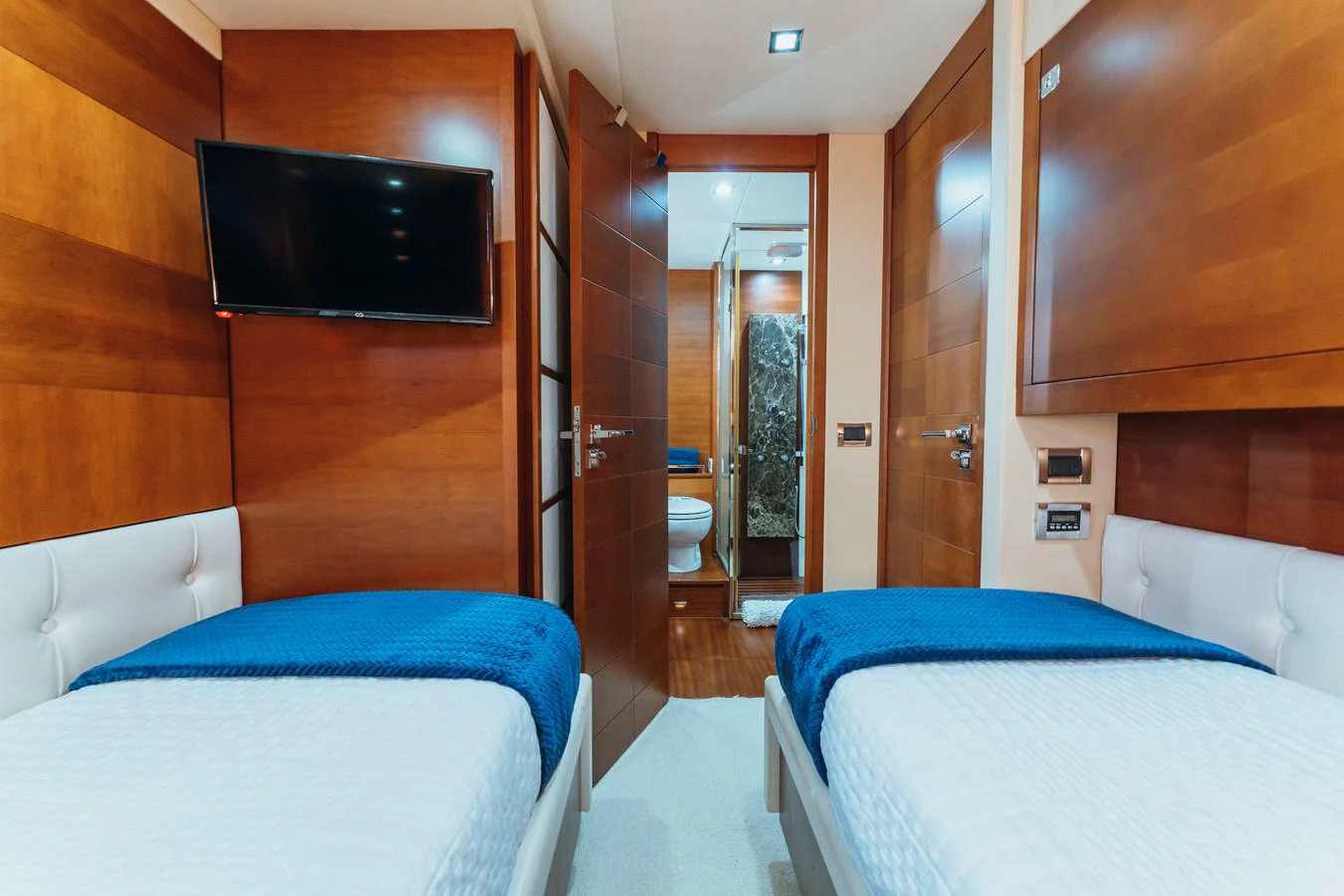 a room with a bed and a television aboard RESET Yacht for Sale