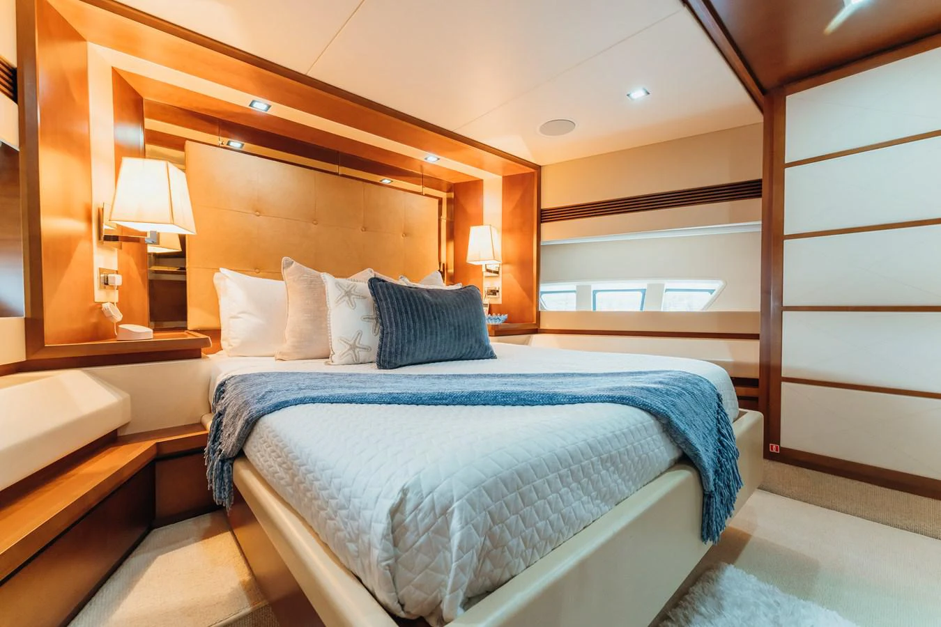a room with a bed and a lamp aboard RESET Yacht for Sale