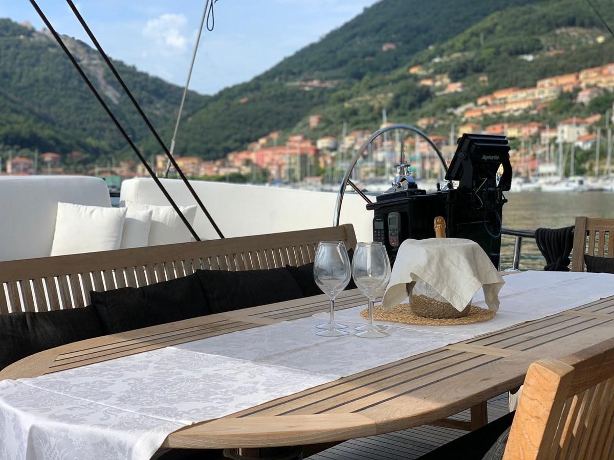 a table with wine glasses and a view of a city aboard BLACKWOOD I Yacht for Sale