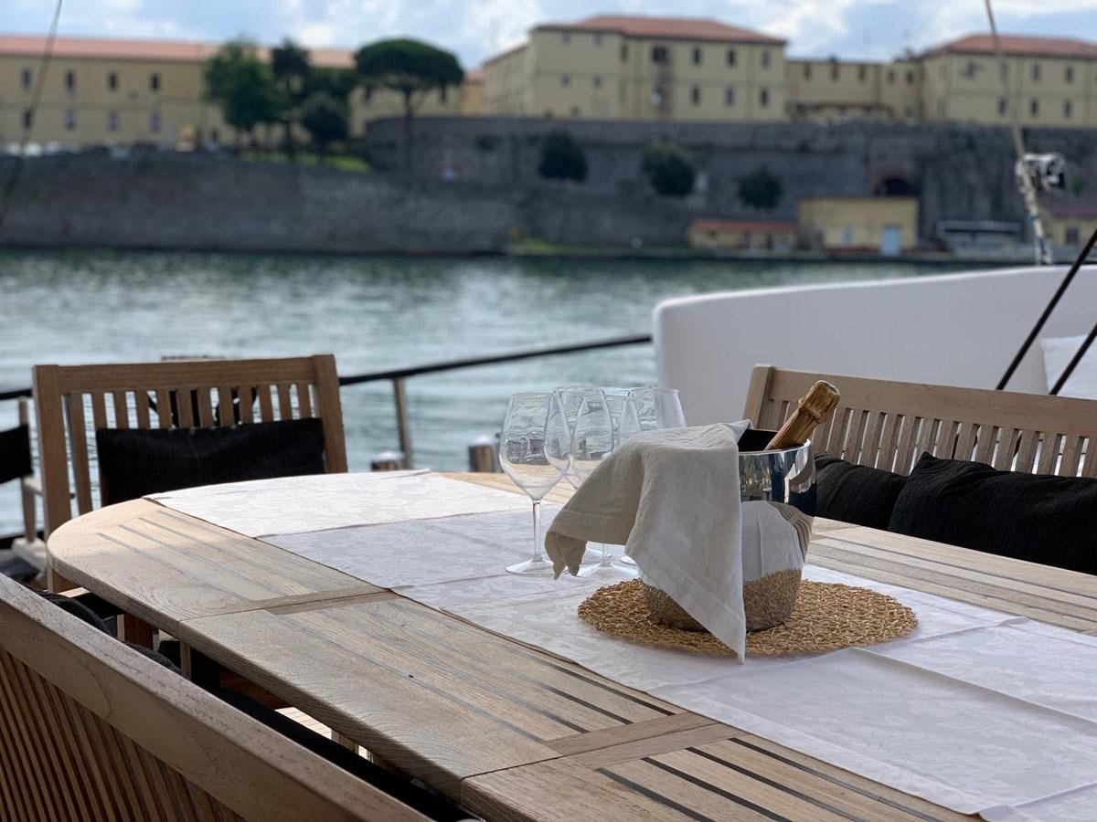 a table with chairs on it next to a body of water aboard BLACKWOOD I Yacht for Sale