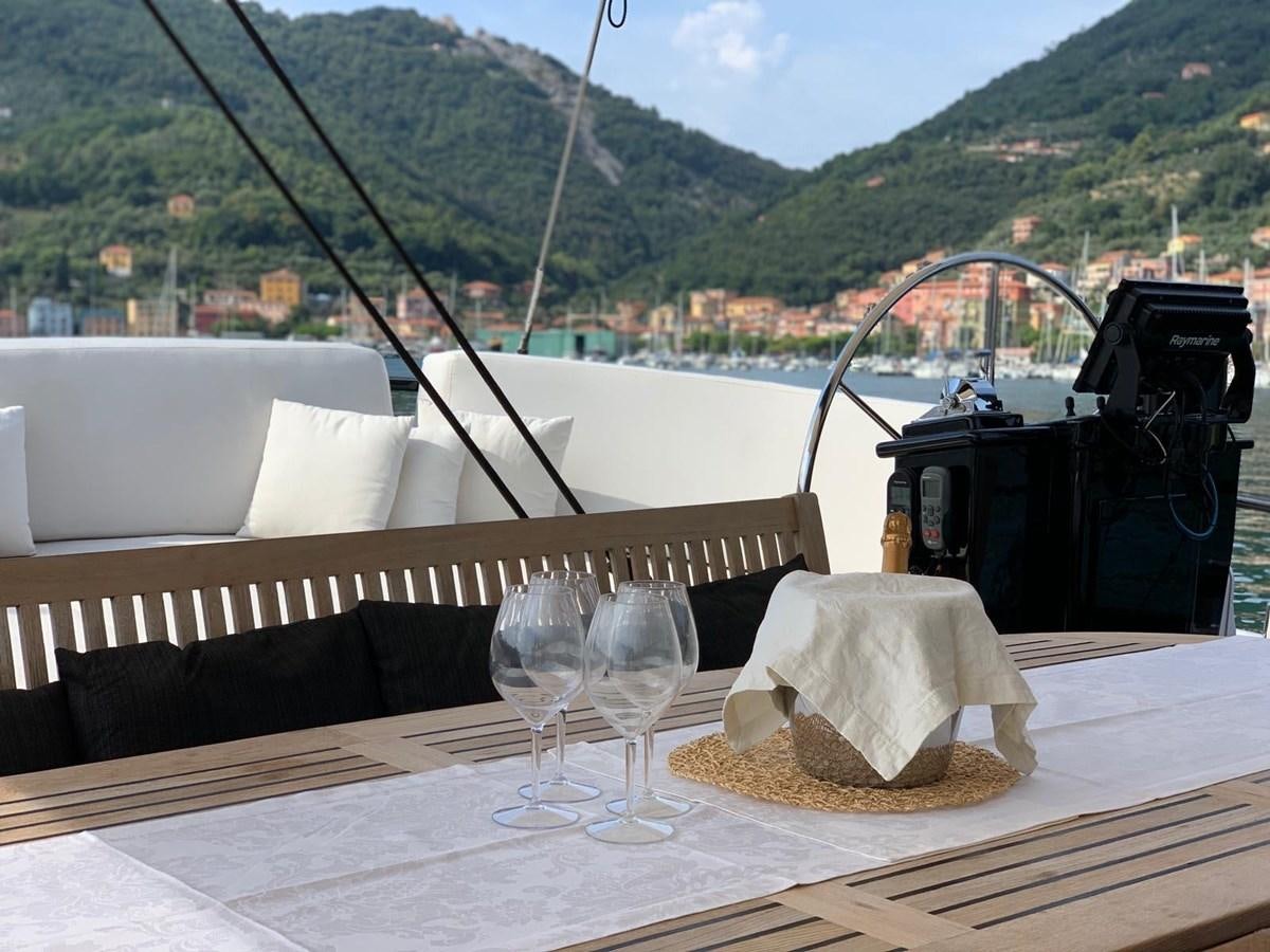 a table with wine glasses and a basket on it aboard BLACKWOOD I Yacht for Sale