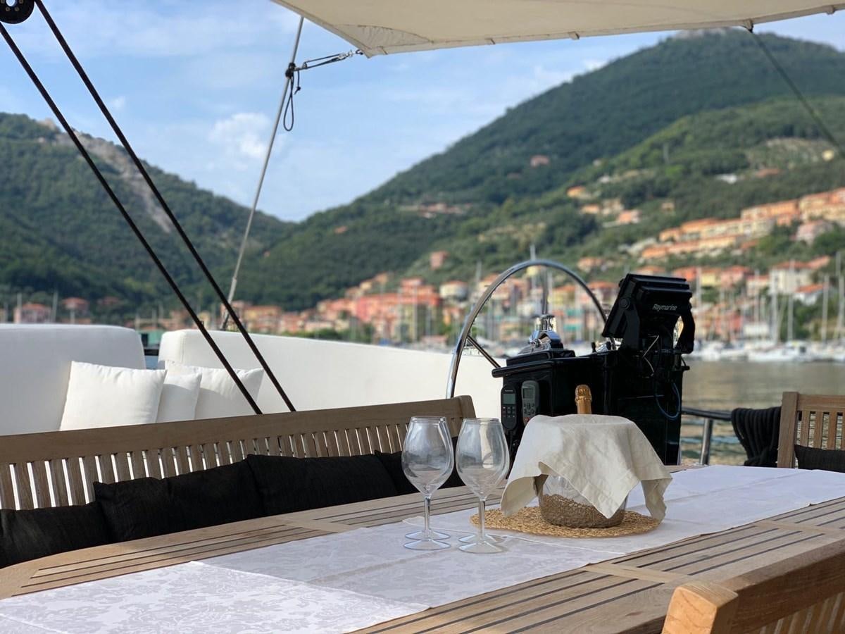 a table with wine glasses and a view of a city aboard BLACKWOOD I Yacht for Sale