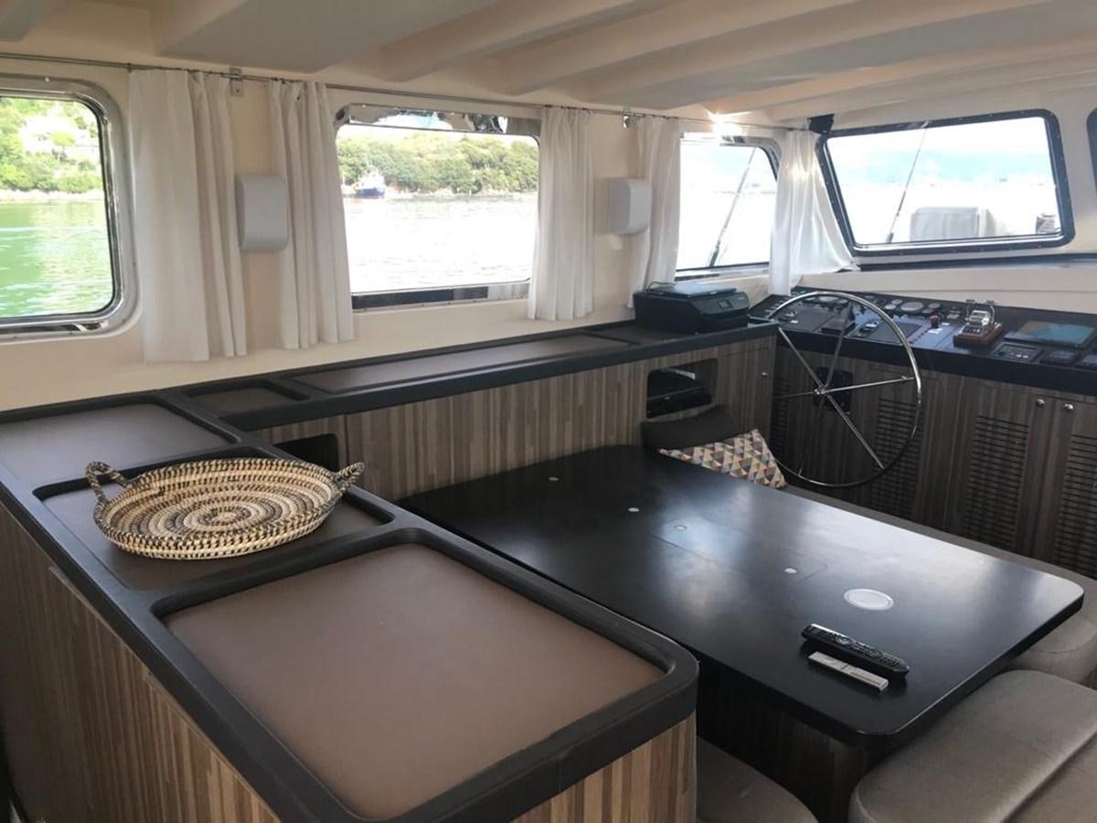a room with a television and a table with a basket on it aboard BLACKWOOD I Yacht for Sale
