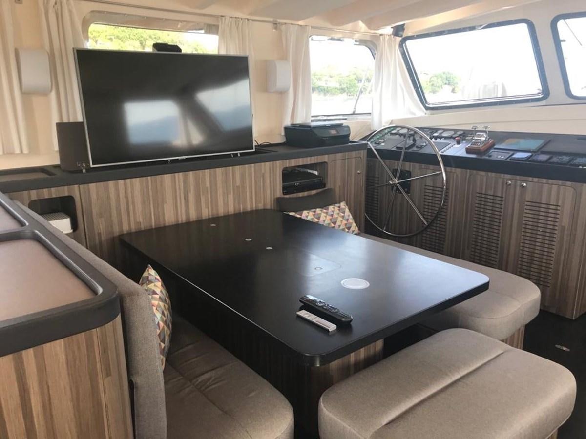 a living room with a tv and a table aboard BLACKWOOD I Yacht for Sale