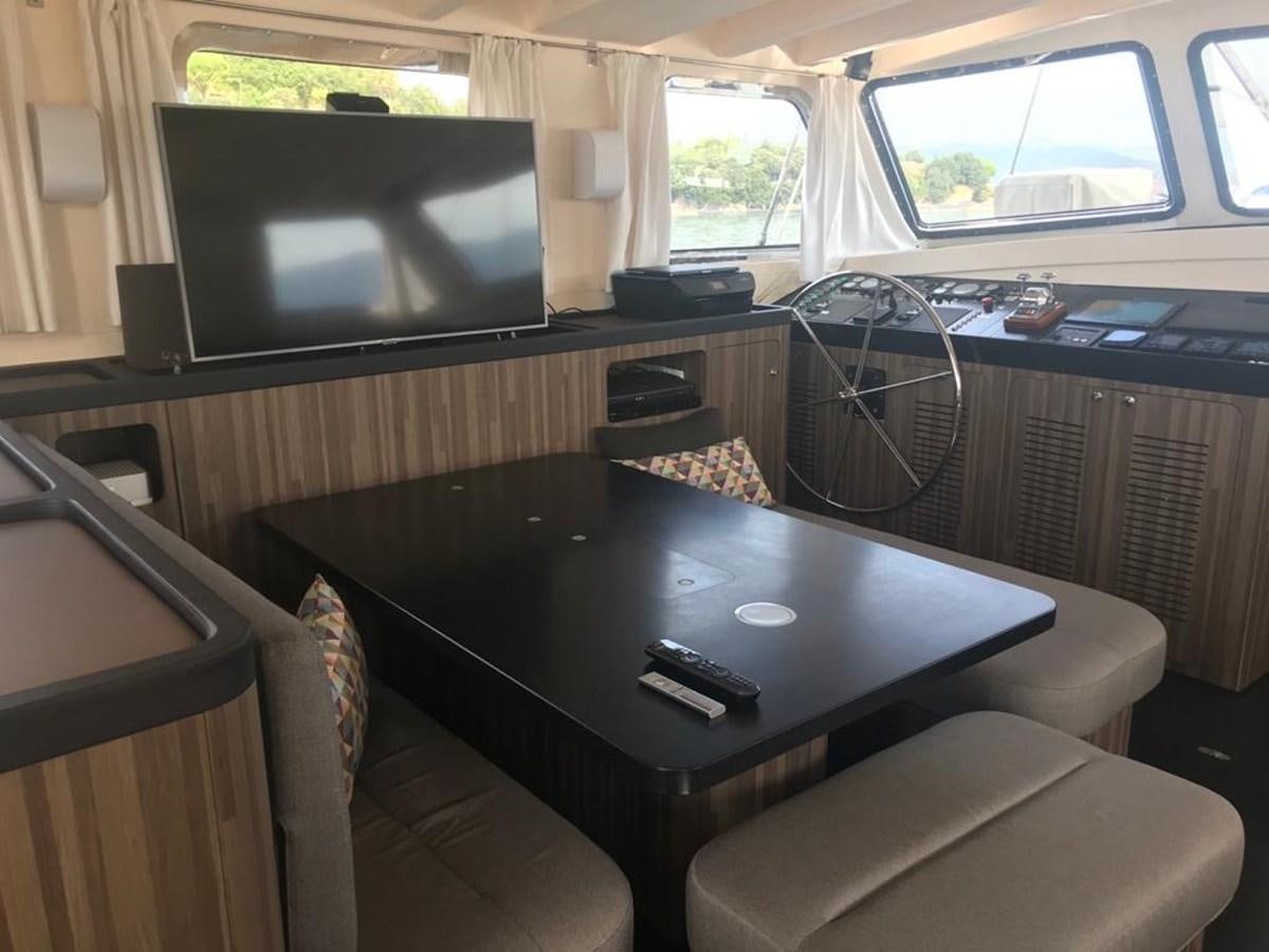 a living room with a tv and a table aboard BLACKWOOD I Yacht for Sale