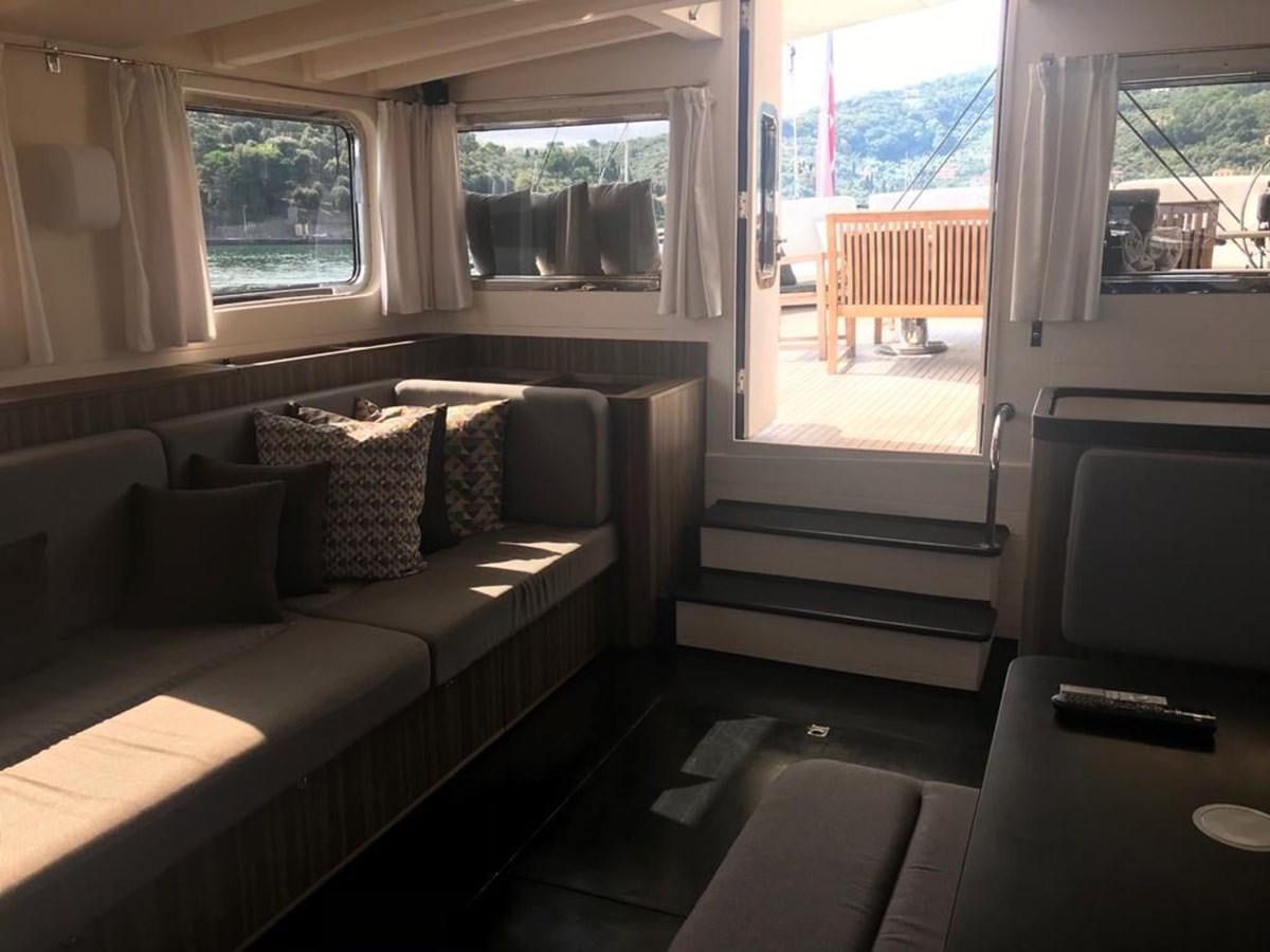 a living room with a couch and a window aboard BLACKWOOD I Yacht for Sale