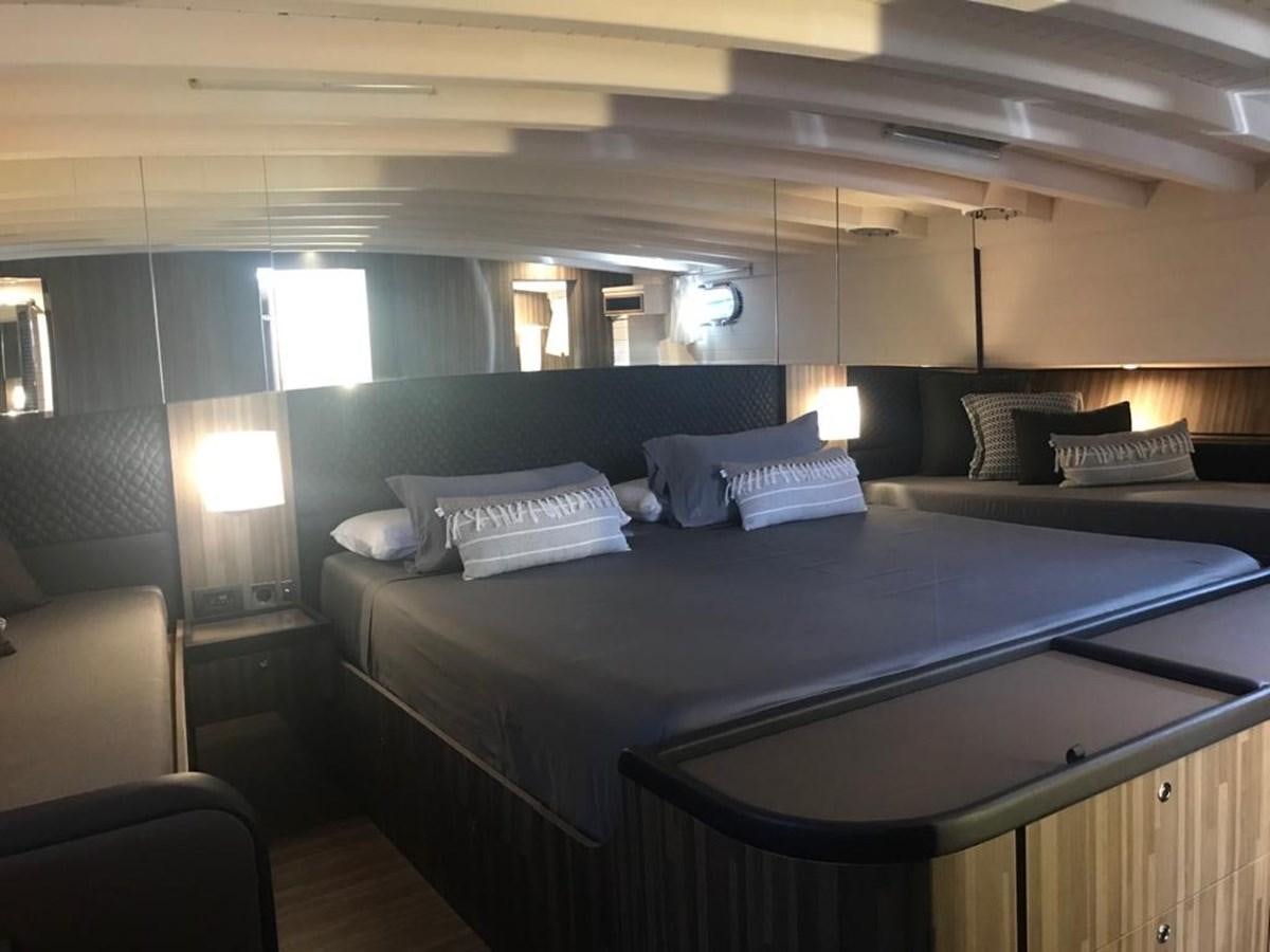 a bed with a desk and a chair aboard BLACKWOOD I Yacht for Sale
