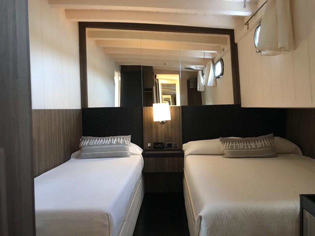a hotel room with two beds aboard BLACKWOOD I Yacht for Sale