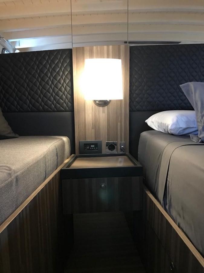 a room with a bed and a lamp aboard BLACKWOOD I Yacht for Sale