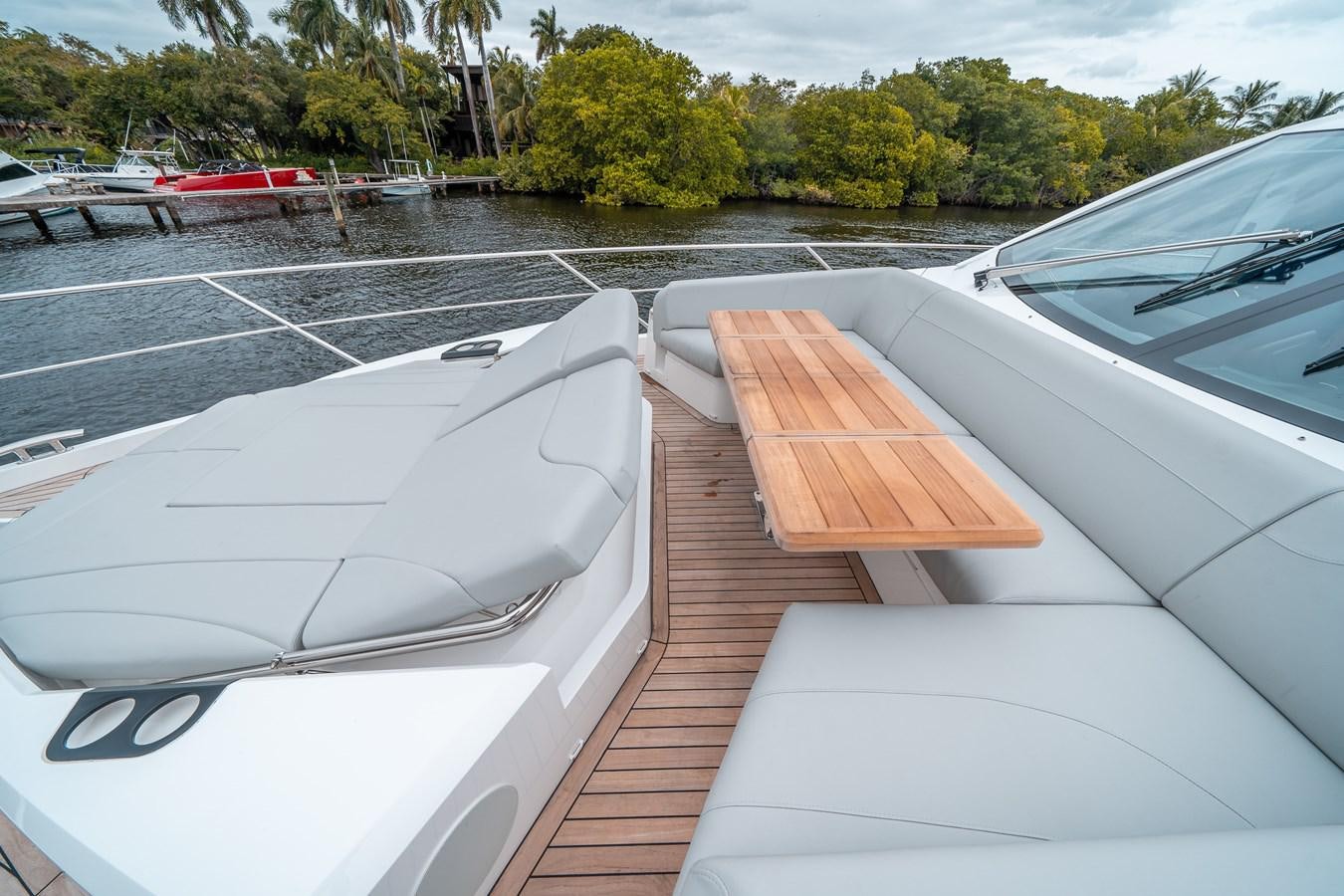 a deck with a boat and a dock with trees in the background aboard MANHATTAN 68 Yacht for Sale