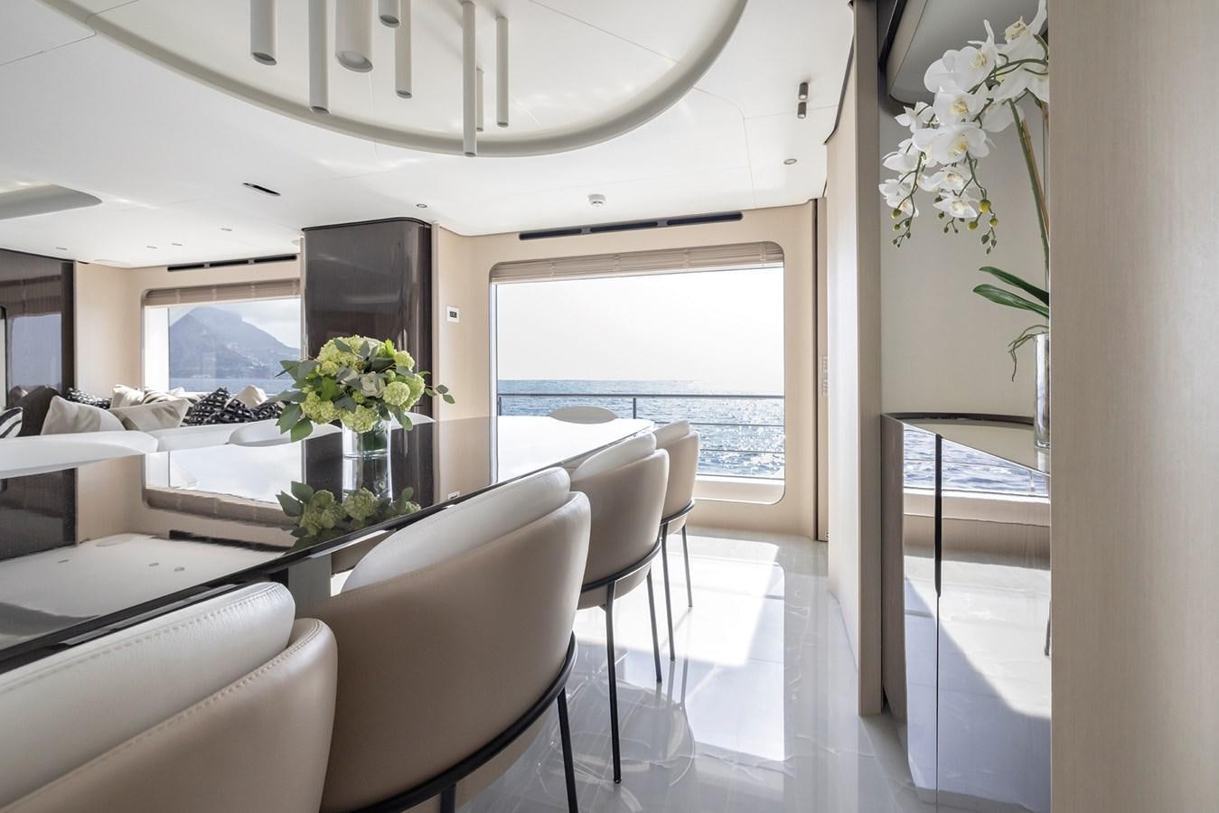 a room with white chairs and a table with flowers on it aboard AZIMUT GRANDE 32M  Yacht for Sale