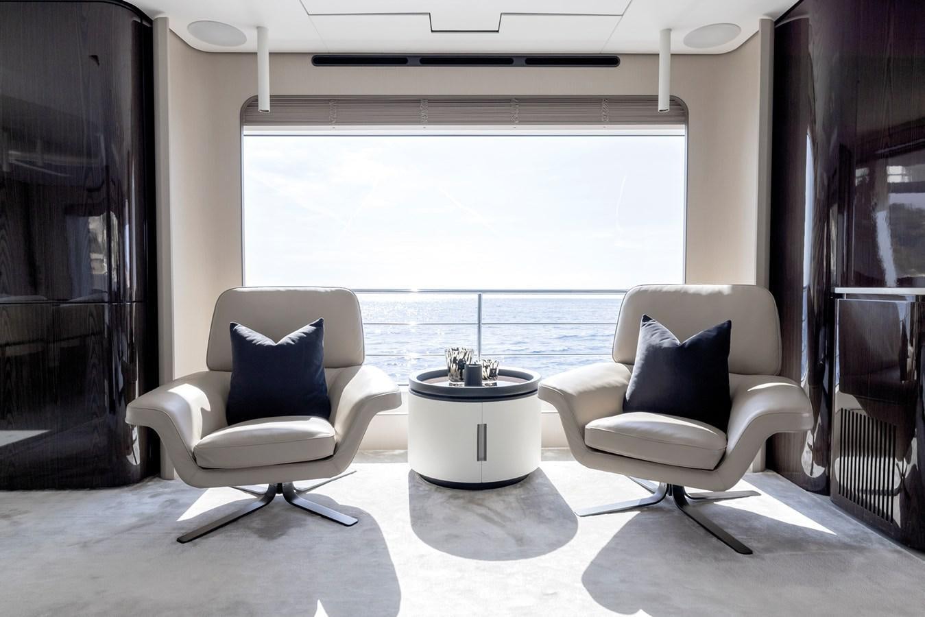 a couple of white chairs in a room with a large window aboard AZIMUT GRANDE 32M  Yacht for Sale