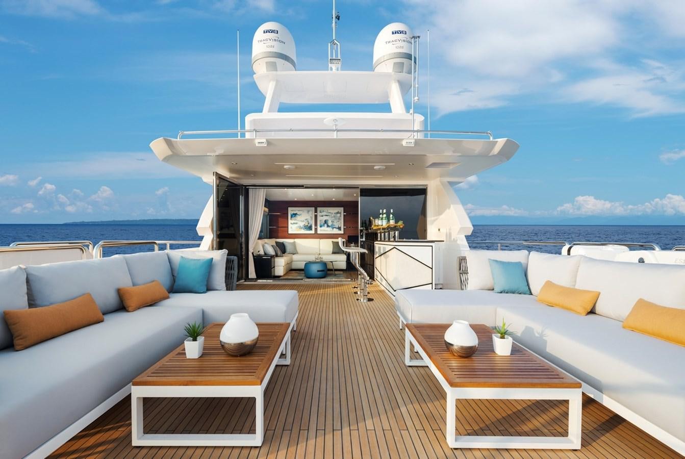 a room with a couch and a table and a large white building with a view of the ocean aboard HORIZON FD90/30 Yacht for Sale