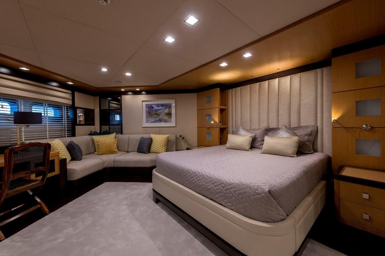a large bedroom with a bed and a couch aboard SERENITY II Yacht for Sale
