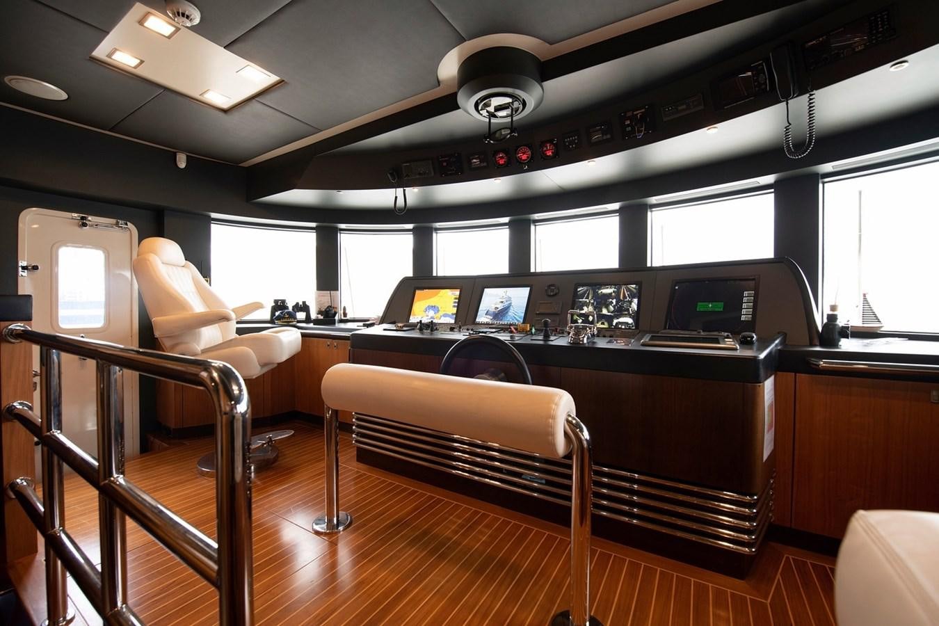 a room with a piano and a desk with chairs and a computer aboard SERENITY II Yacht for Sale