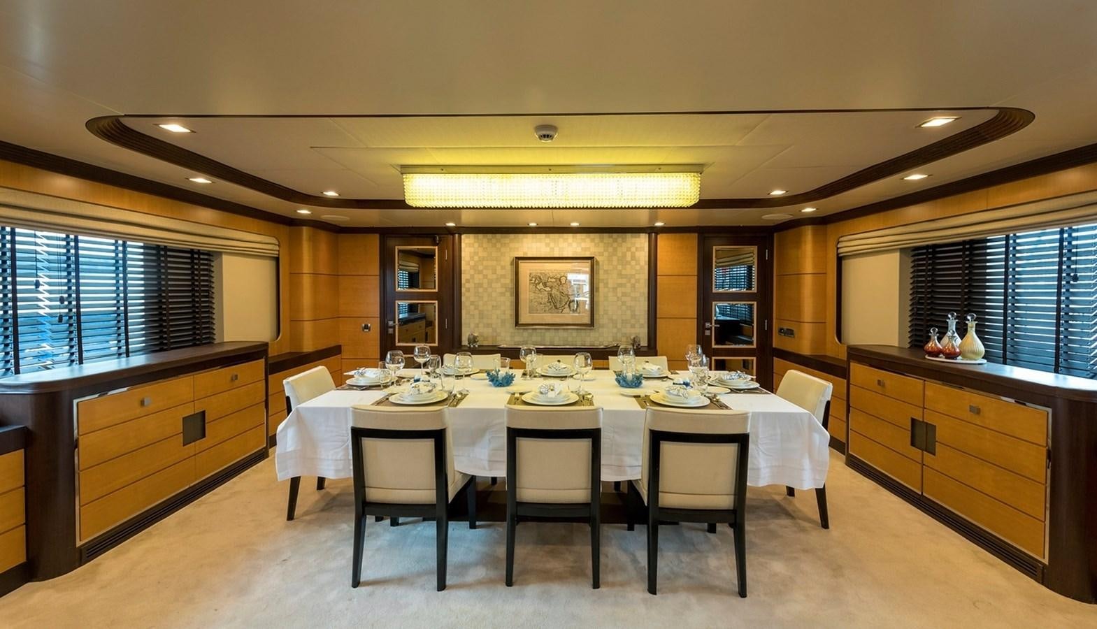 a large dining table in a large room aboard SERENITY II Yacht for Sale