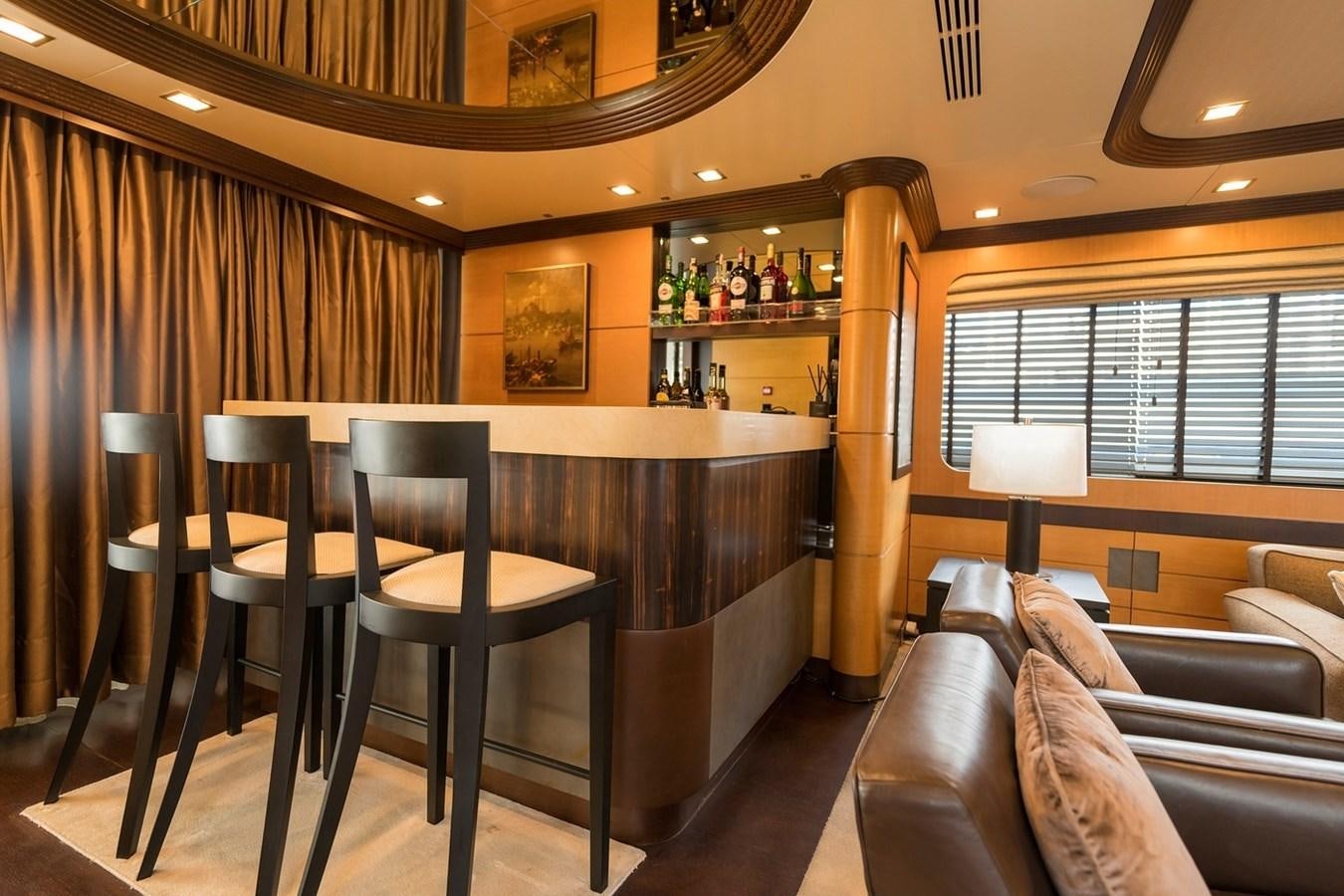 a room with a bar and a table and chairs aboard SERENITY II Yacht for Sale