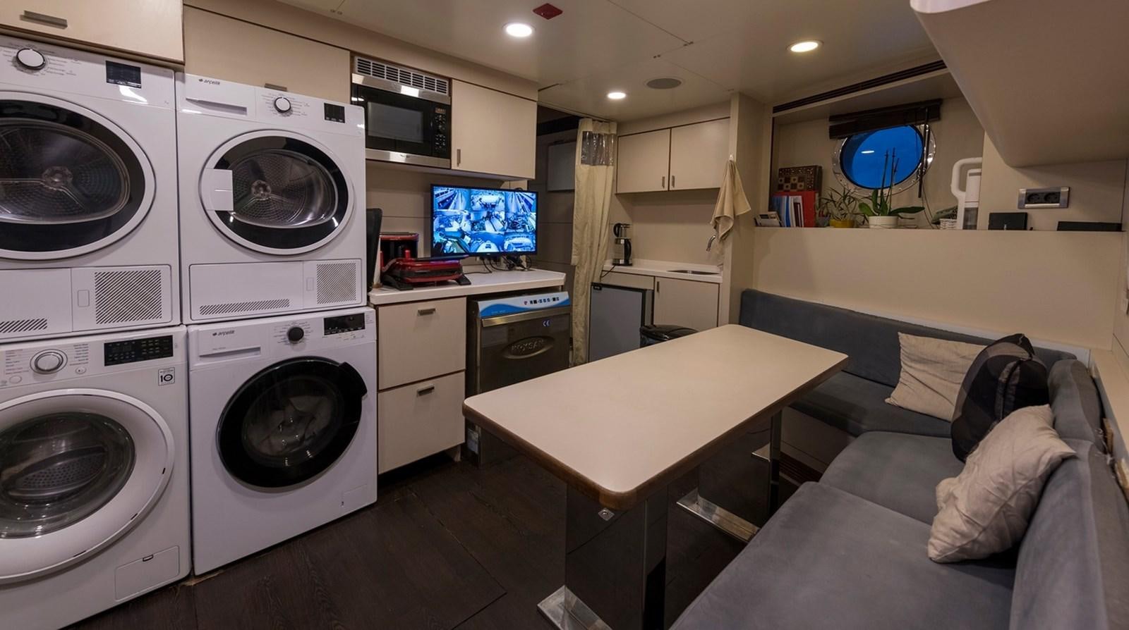 a room with a bed and a couch and a television aboard SERENITY II Yacht for Sale