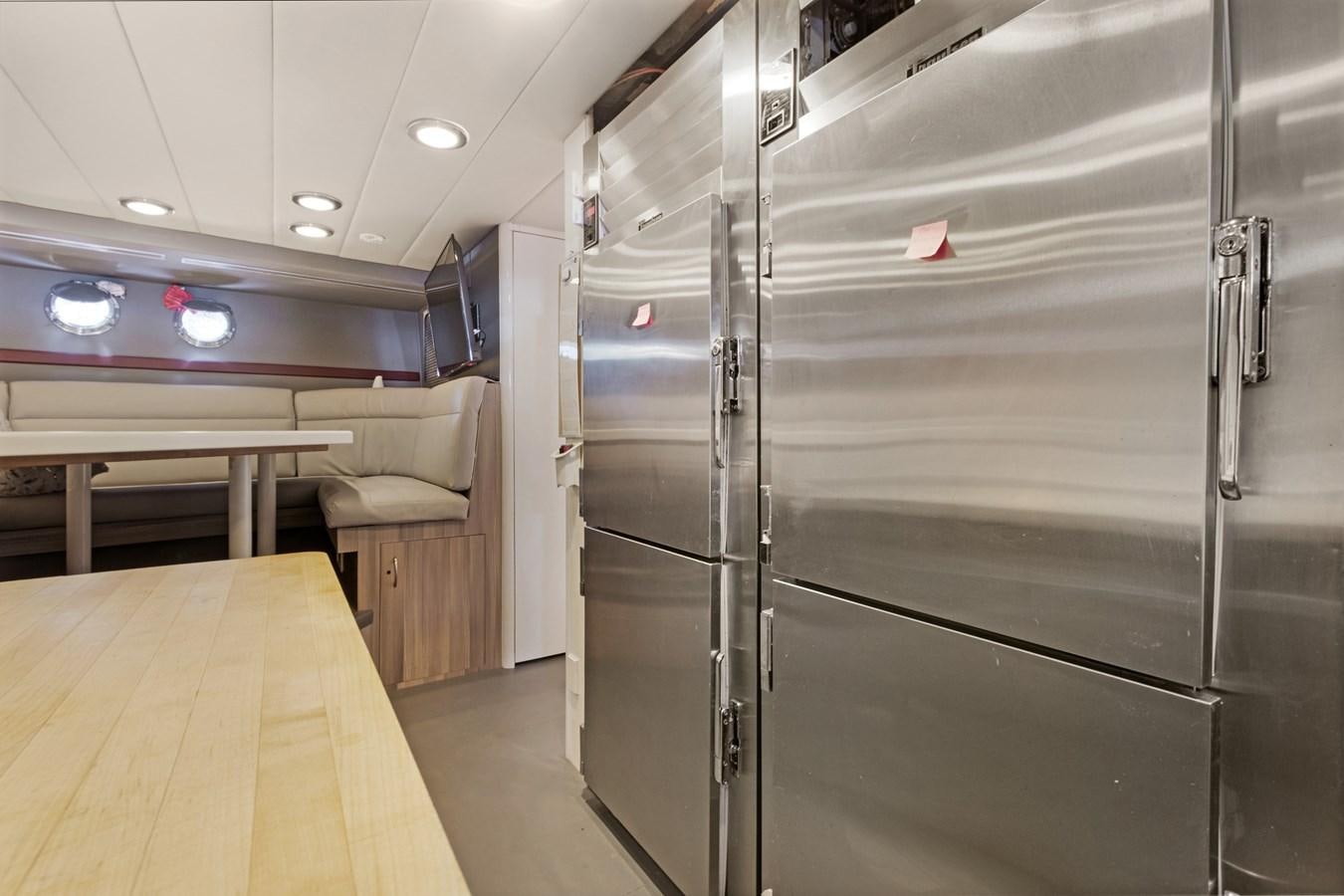a room with a large wall of lockers and a table aboard MAC Yacht for Sale