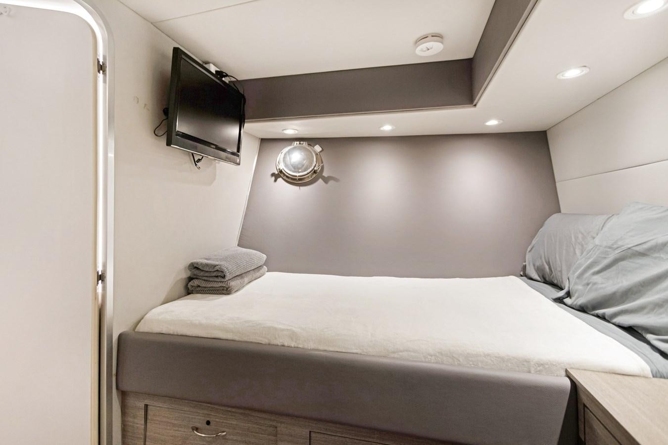 a bed with a television on the wall aboard MAC Yacht for Sale