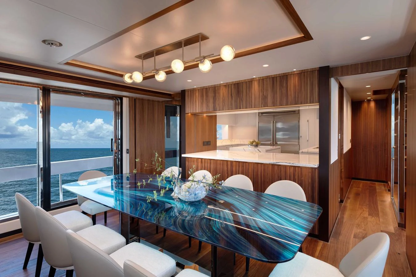 a large dining room with a large blue table and chairs aboard HORIZON FD100/911 Yacht for Sale