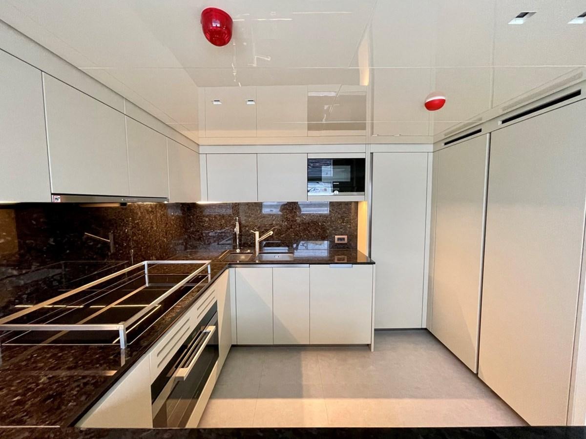 a kitchen with white cabinets aboard INS LAND Yacht for Sale