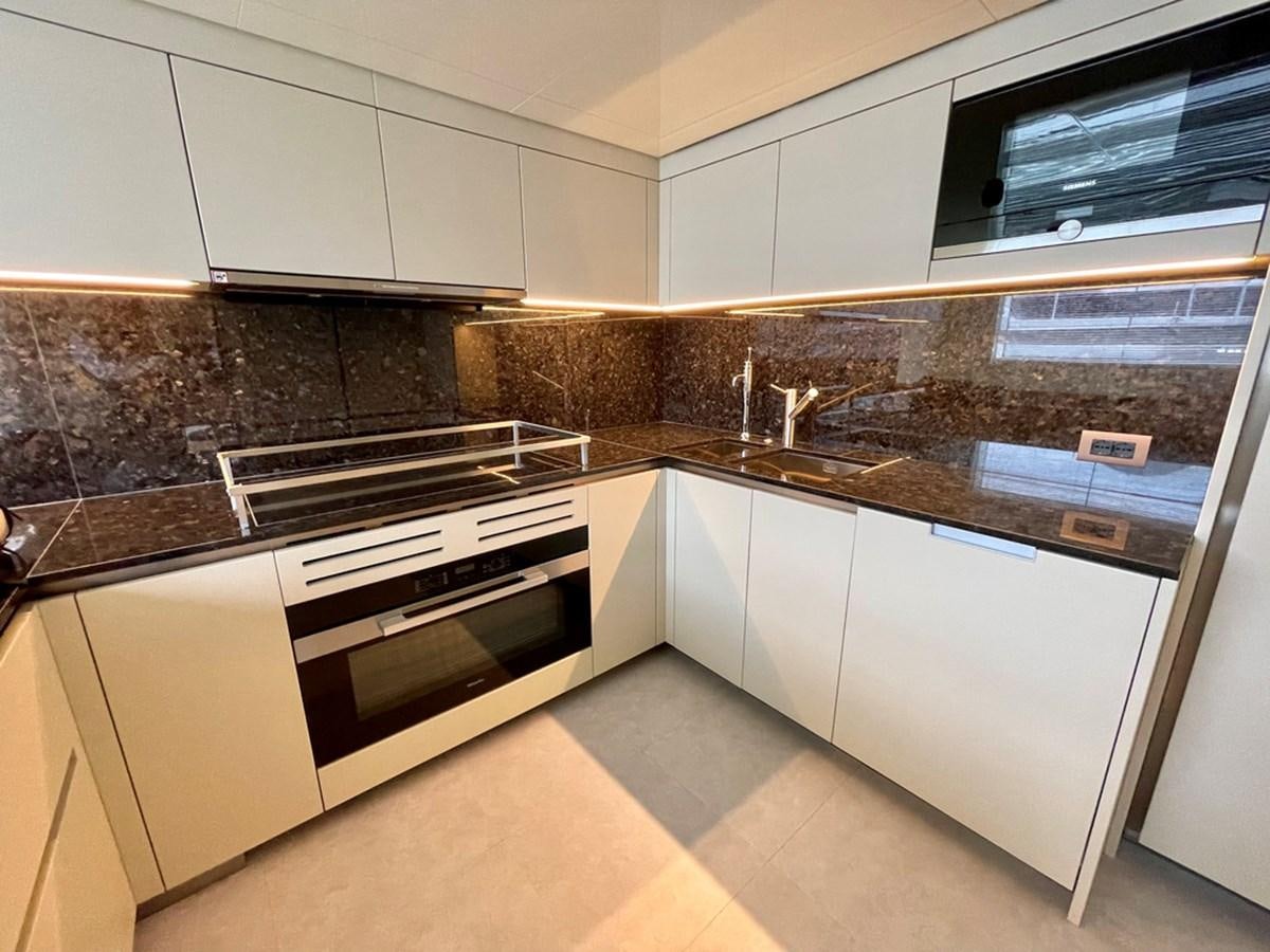 a kitchen with white cabinets aboard INS LAND Yacht for Sale