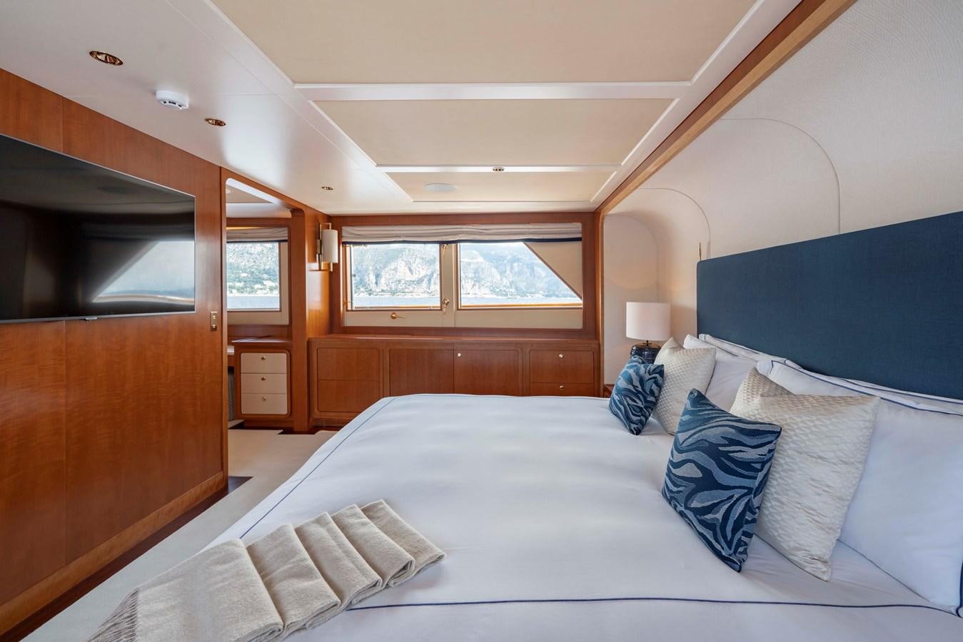 a bed with blue pillows aboard SYNTHESIS 66 Yacht for Sale