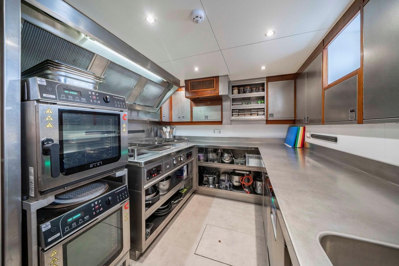 a kitchen with stainless steel appliances aboard SYNTHESIS 66 Yacht for Sale