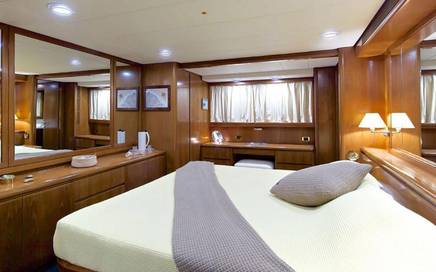 a hotel room with a bed and a mirror aboard JUNESTAR Yacht for Sale