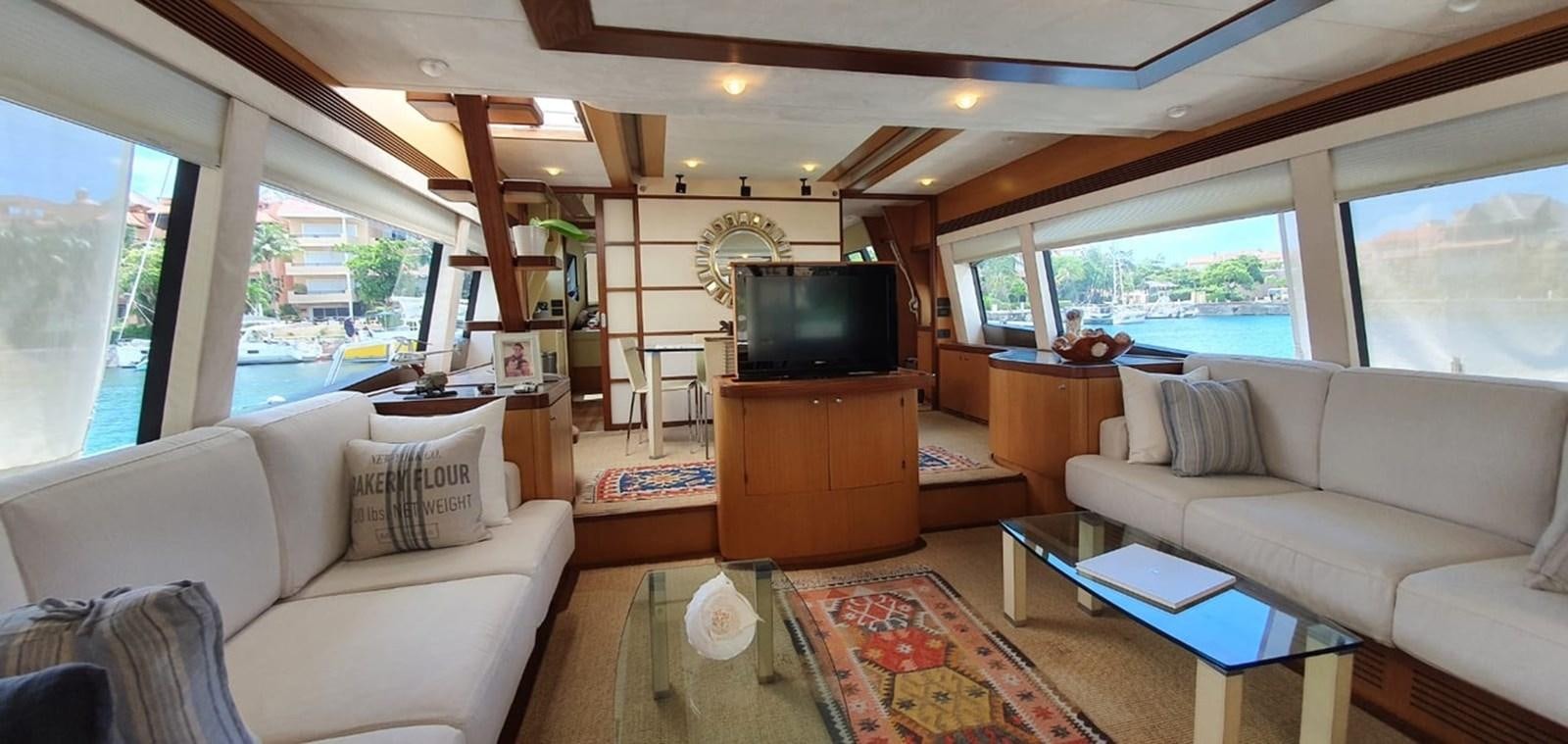a living room with a tv and couches aboard SEDROP - 2006 FERRETTI 731 @ PTO. AVENTURAS Yacht for Sale
