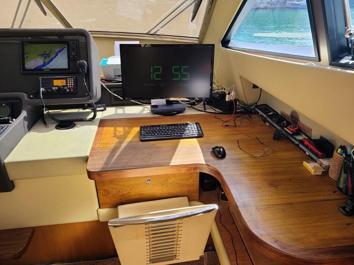 a desk with a computer and a chair aboard SEDROP - 2006 FERRETTI 731 @ PTO. AVENTURAS Yacht for Sale