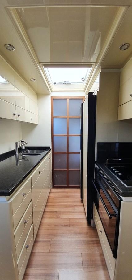 a kitchen with a wood floor aboard SEDROP - 2006 FERRETTI 731 @ PTO. AVENTURAS Yacht for Sale