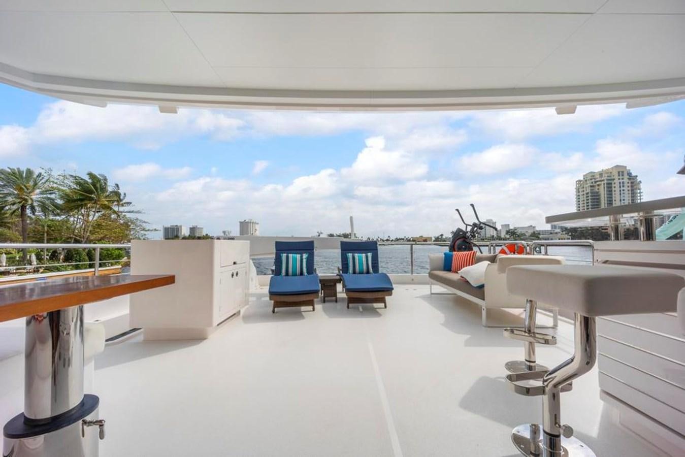 a room with a pool and a deck with chairs and a table aboard BELLA TU Yacht for Sale