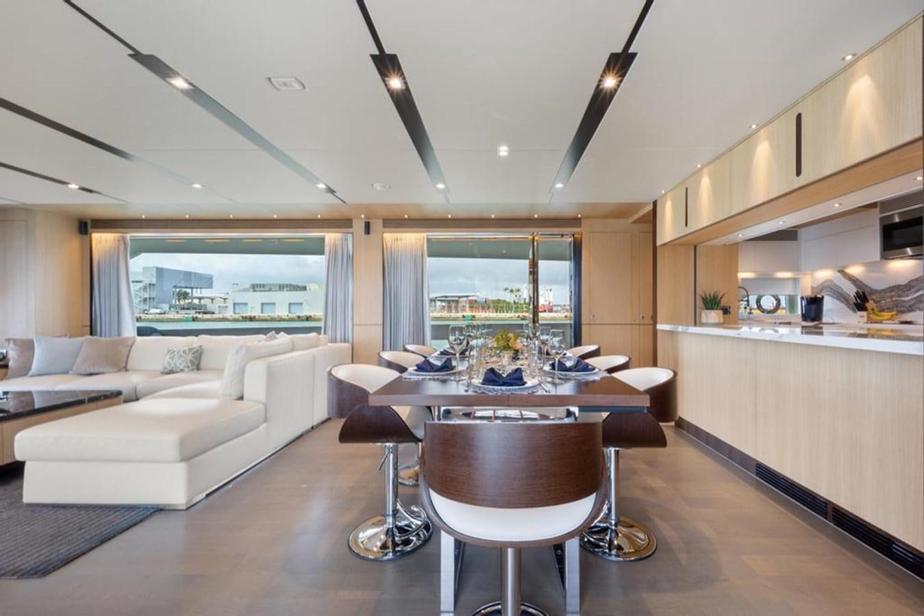 a living room with a table and couches aboard BELLA TU Yacht for Sale