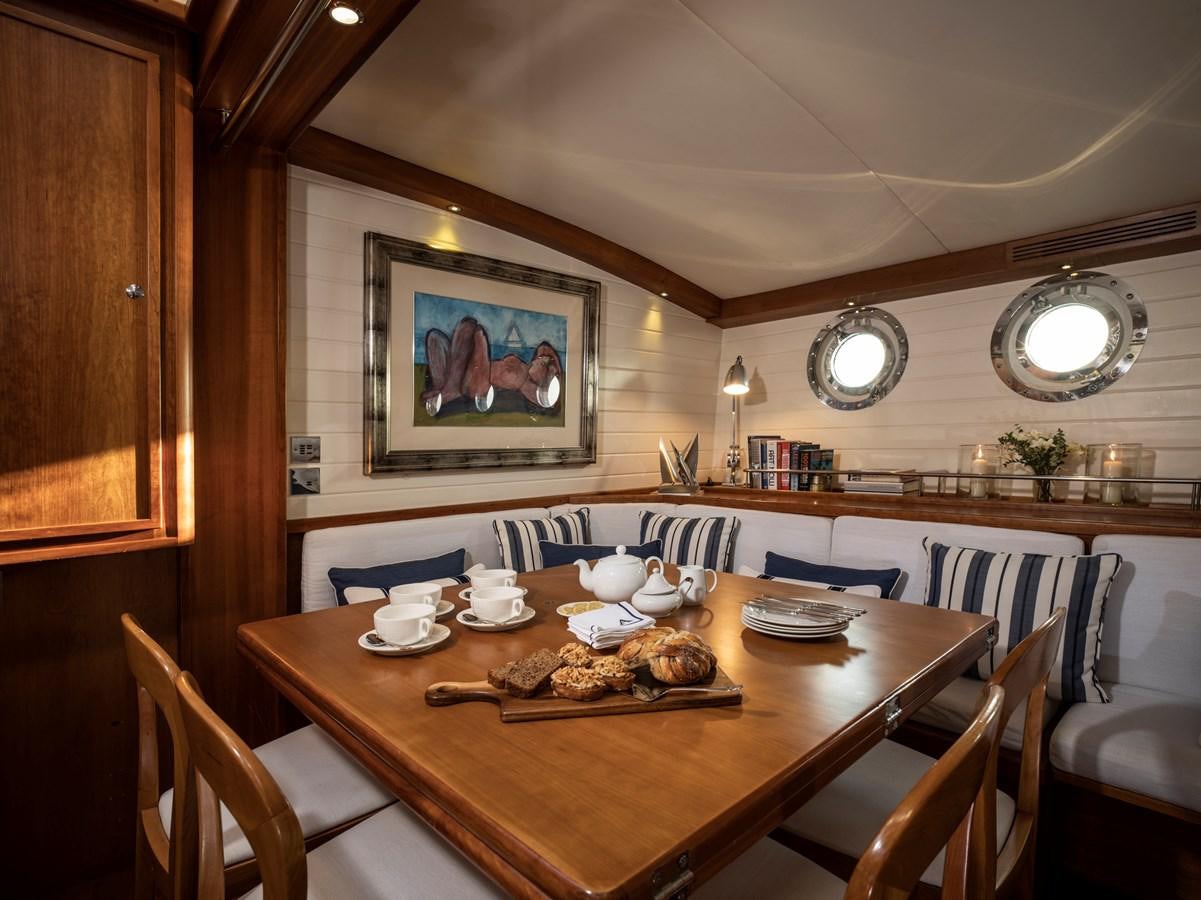 a dining table with a painting on the wall aboard ALEXA OF LONDON Yacht for Sale