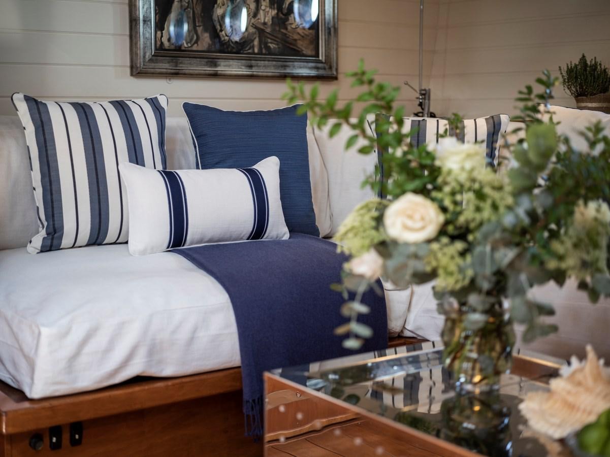 a blue and white bed with a blue blanket and a vase of flowers aboard ALEXA OF LONDON Yacht for Sale